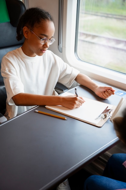 Bezpłatne zdjęcie Średnio zastrzelona dziewczyna podróżująca pociągiem