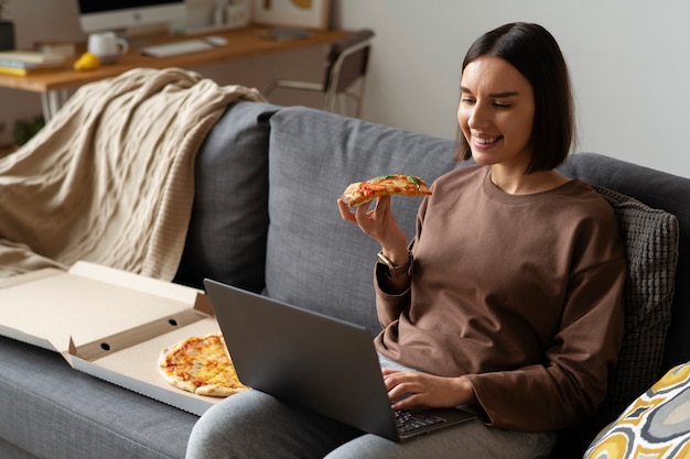 Średnio zastrzelona kobieta jedząca pyszną pizzę