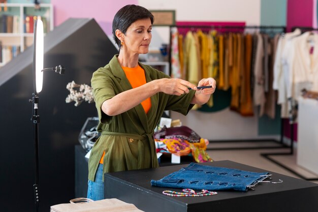 Średnio zastrzelona kobieta naprawiająca modne towary