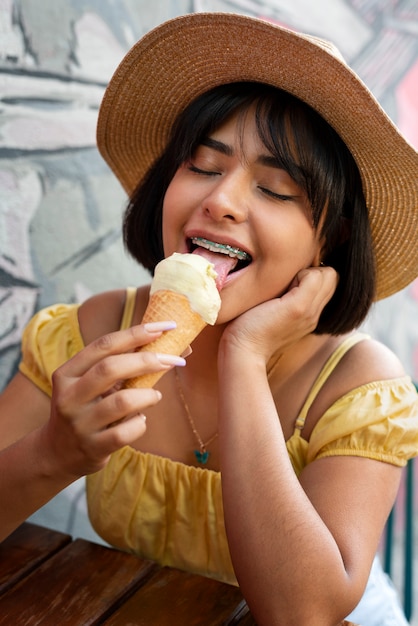 Bezpłatne zdjęcie Średnio zastrzelony latynoska kobieta jedząca lody