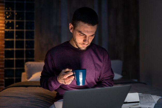 Średnio zastrzelony mężczyzna pracujący późno w nocy na laptopie