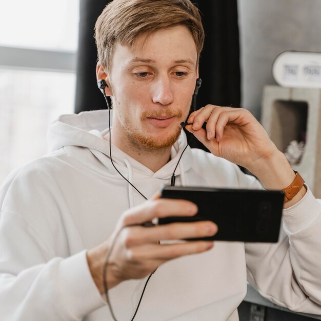 Średnio zastrzelony mężczyzna z telefonem i słuchawkami