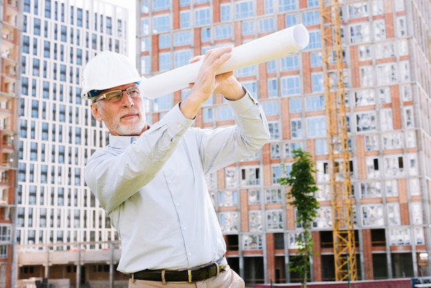 Średnio zastrzelony stary architekt z planami budynków