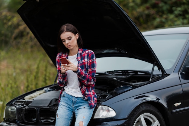 Środek strzelający kobieta sprawdza telefon