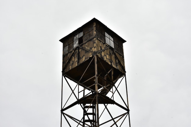 Bezpłatne zdjęcie stara drewniana wieża strażnicza na tle zachmurzonego nieba
