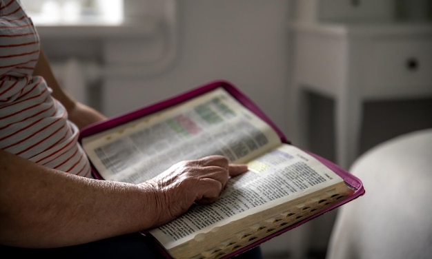 Bezpłatne zdjęcie stara kobieta czyta biblię z bliska