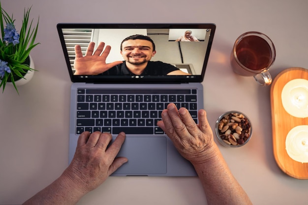 Bezpłatne zdjęcie stara kobieta komunikuje się z synem za pośrednictwem łącza wideo za pośrednictwem laptopa