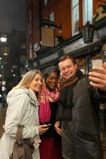 Starsi ludzie bawiący się na imprezie i robiący selfie