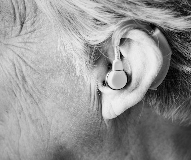 Starsza kobieta nosząca aparat słuchowy