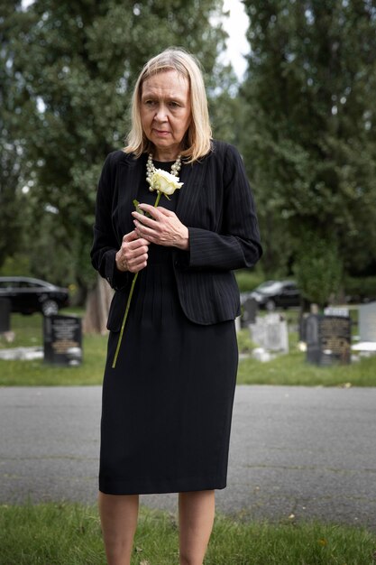 Starsza kobieta odwiedzająca grób ukochanej osoby