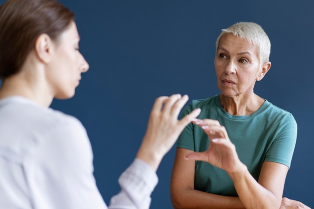 Starsza kobieta podczas sesji terapii zajęciowej z psychologiem