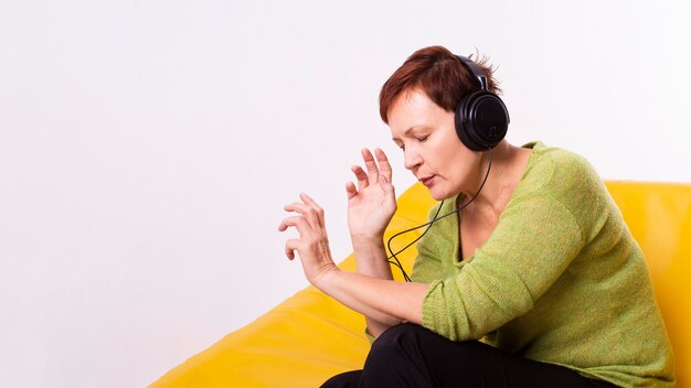 Starsza kobieta relaksuje słuchającą muzyką