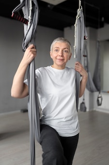 Starsza kobieta robi rozgrzewkę na siłowni