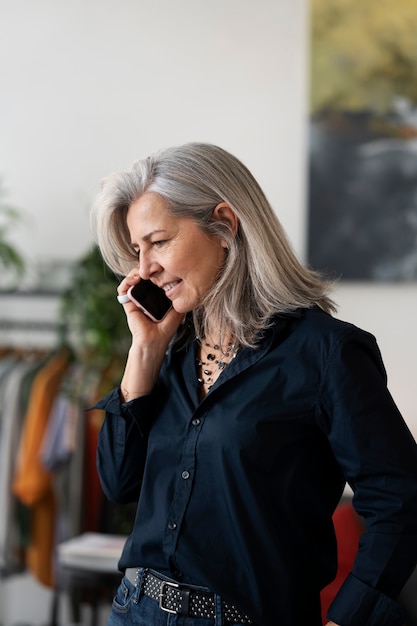 Bezpłatne zdjęcie starsza kobieta rozmawia przez telefon średni strzał