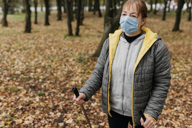 Starsza Kobieta Z Maską Medyczną I Kije Trekkingowe Na Zewnątrz