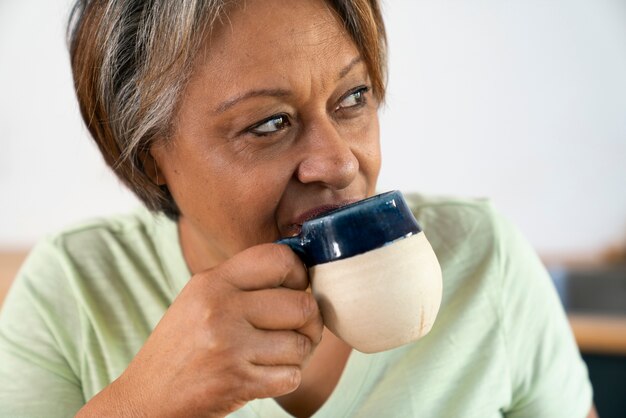 Starsza kobieta z widokiem z przodu filiżanki kawy