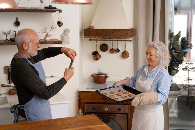 Starsza para robi zdjęcie ciasteczek w kuchni