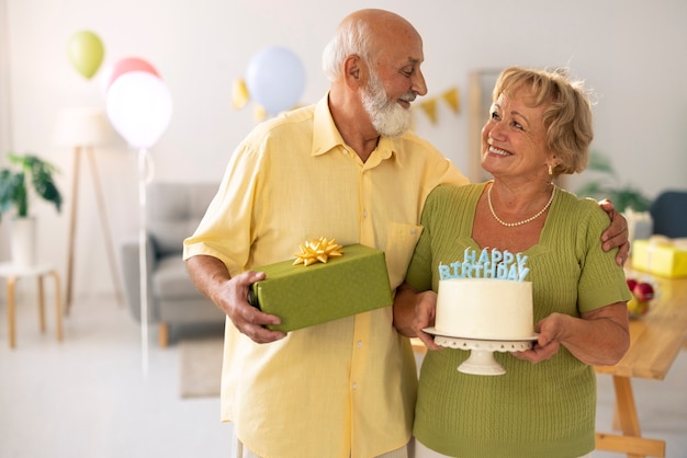 Bezpłatne zdjęcie starsza para z tortem urodzinowym i prezentem