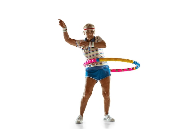 Starszy kobieta nosi trening sportowy z obręczą na białej ścianie