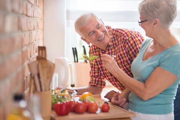 Starszy małżeństwo gotuje razem zdrowy posiłek