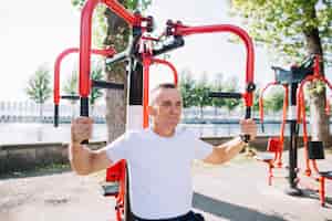 Bezpłatne zdjęcie starszy mężczyzna ćwiczy mięśnie ramion