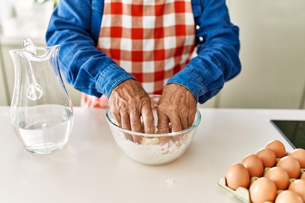 Bezpłatne zdjęcie starszy mężczyzna gotuje ciasto w kuchni