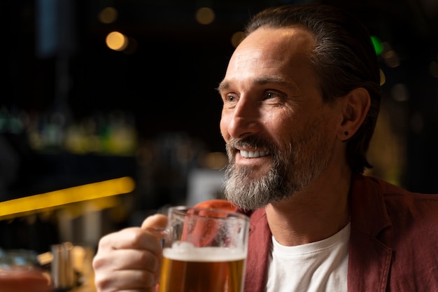 Bezpłatne zdjęcie starszy mężczyzna pijący piwo