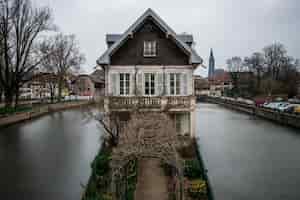 Bezpłatne zdjęcie stary budynek otoczony wodą i zielenią pod zachmurzonym niebem w strasburgu we francji