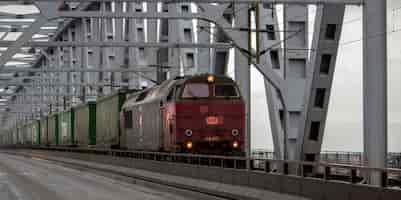 Bezpłatne zdjęcie stary czerwony pociąg z zielonymi furgonami podczas dnia