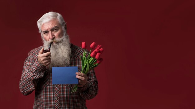 Stary człowiek trzyma kwiaty