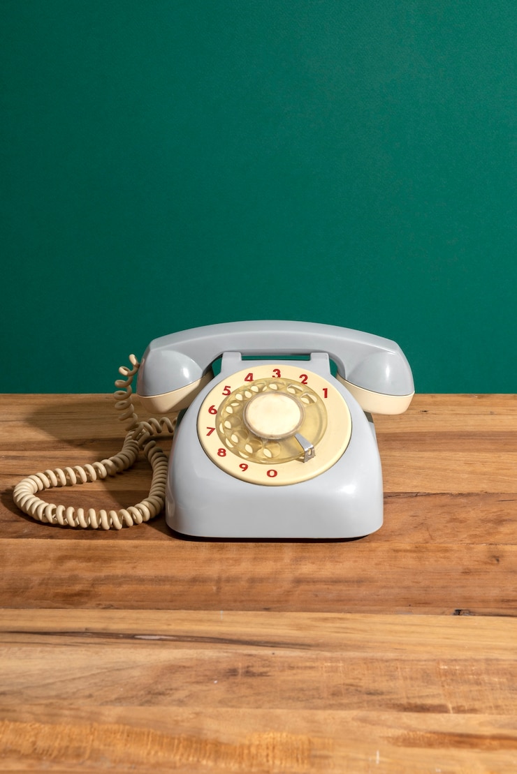 Bezpłatny plik Zdjęcie stary telefon na drewnianym stole z wysokim kątem