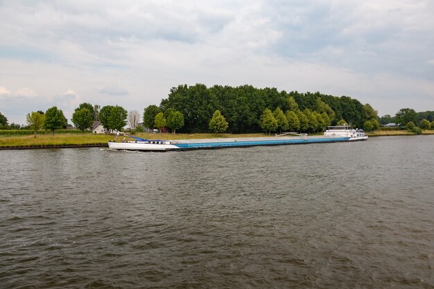 Statek transportu śródlądowego pod zachmurzonym niebem w Holandii