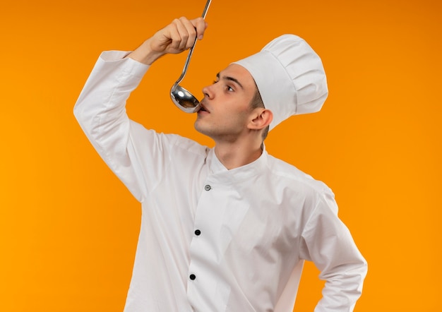 Stojący W Widoku Profilu Młody Mężczyzna Fajny Ubrany W Mundur Szefa Kuchni Próbuje Zupy Z Kadzi
