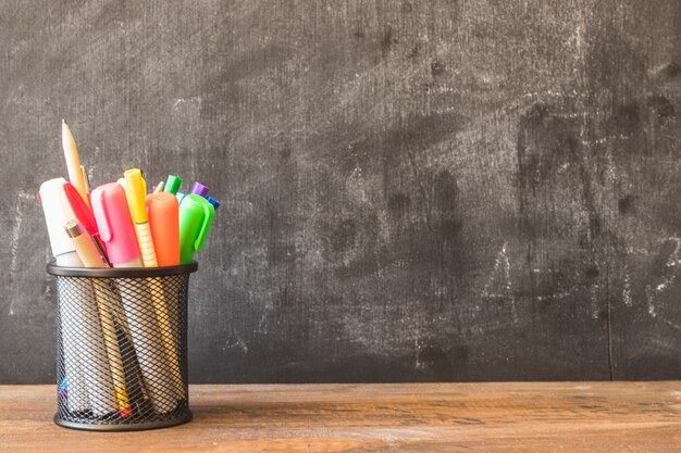 Stół z ołówkową filiżanką blisko blackboard