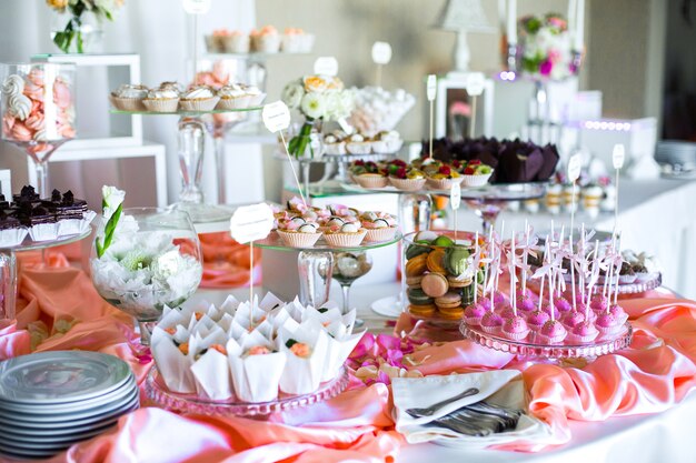 Stół z pysznymi słodyczami pokrytymi różowym jedwabiem