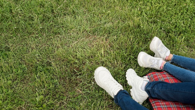 Bezpłatne zdjęcie stopy pary na kocu piknikowym