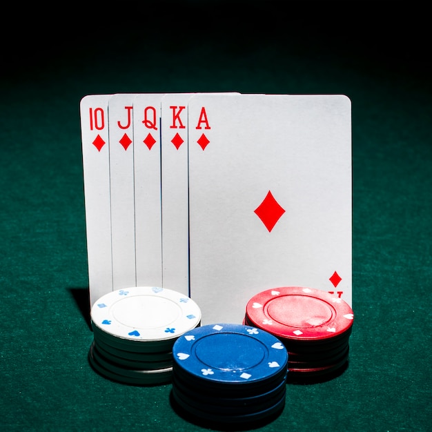 Bezpłatne zdjęcie stos żetonów w kasynie z przodu karty poker królewski poker na stole pokerowym
