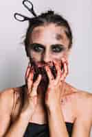 Bezpłatne zdjęcie straszna kobieta z nożyczkami w głowie dotykając twarzy