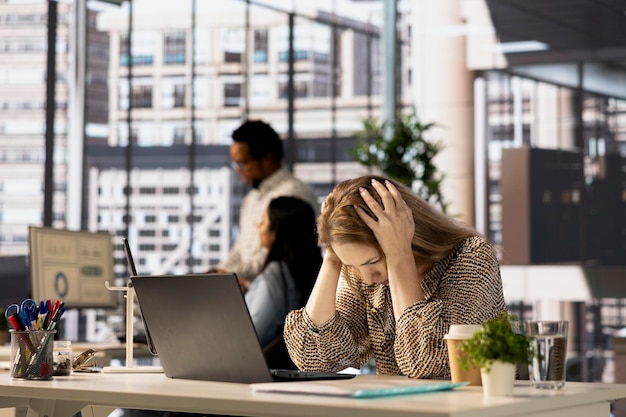 Stresowana bizneswoman boryka się z migreną z powodu presji korporacyjnej