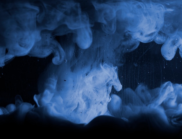 Streszczenie ciężki niebieski dym w ciemnym płynie