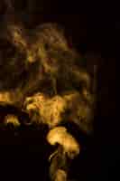 Bezpłatne zdjęcie streszczenie żółty dym na czarnym tle