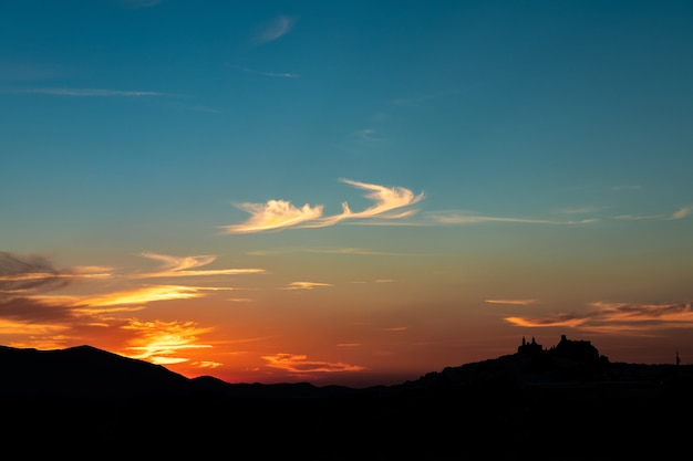 Strzał sylwetka na panoramę miasta Olvera, Hiszpania podczas pięknego zachodu słońca