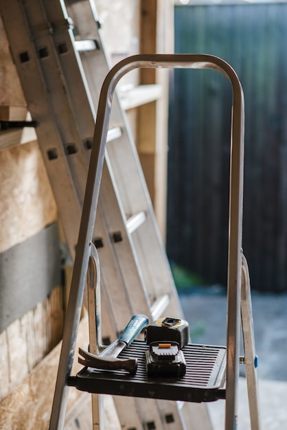 Bezpłatne zdjęcie strzał zbliżenie hummer i narzędzia na schodach podczas budowy domu