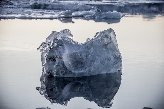 Strzał zbliżenie kawałka lodu unoszącego się w oceanie i odzwierciedlone w nim w Jokulsarlon, Islandia