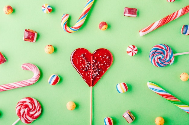 Strzał zbliżenie laski candy i inne cukierki na zielonym tle - perfcet na fajną tapetę