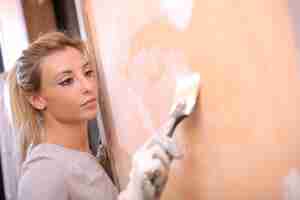 Bezpłatne zdjęcie strzał zbliżenie młodej kobiety blondynka malowanie ściany pod światłami
