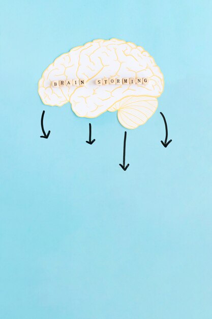 Strzałki w dół spadające z białego mózgu z burzy mózgów bloków na niebieskim tle