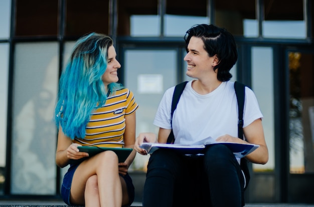 Studenci studiujący na schodach, patrząc na siebie