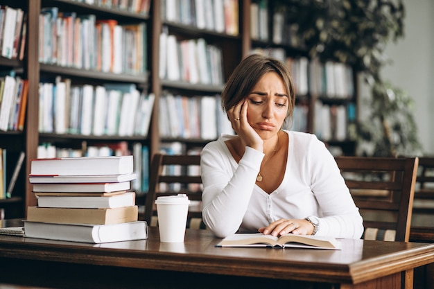 Studencka kobieta studiuje w bibliotece