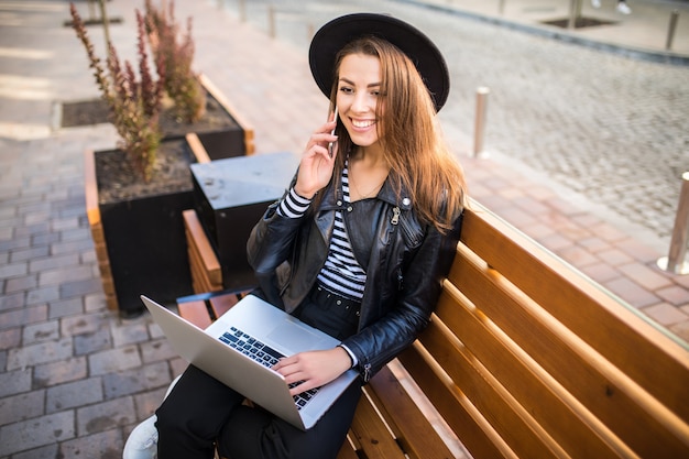 Student dziewczyna biznes kobieta siedzi na drewnianej ławce w mieście w parku jesienią